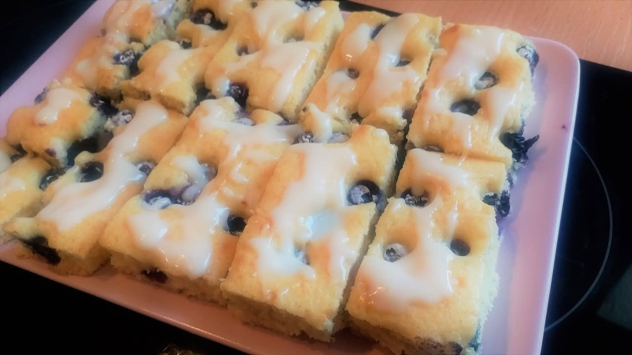 Lemon and blueberry sheet cake, dotted with blueberries.