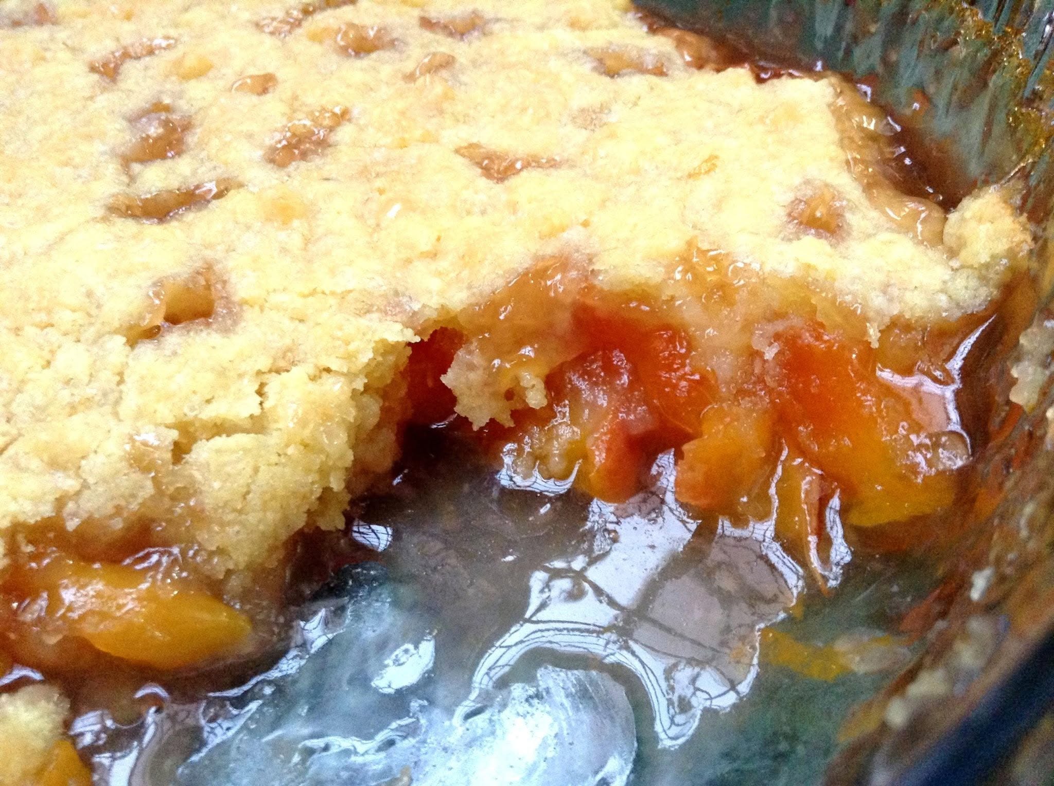 A warm peach cobbler with a golden buttery topping.