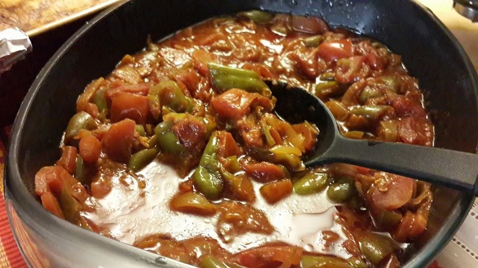 A pot of slow-cooked ratatouille with peppers, tomatoes and herbs.